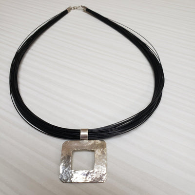Silver hammered pendant on a multi strand black cord - LB Designs