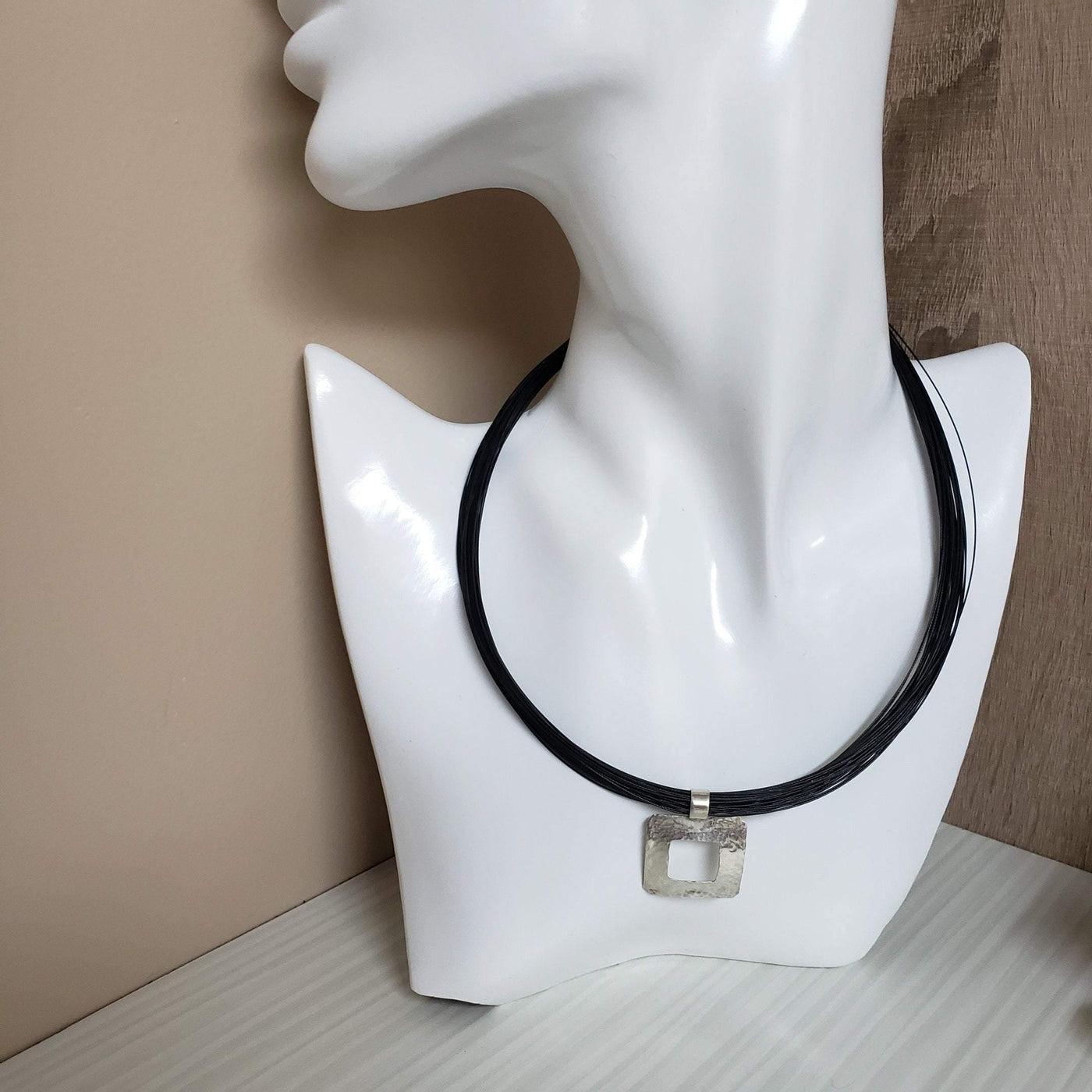 Silver hammered pendant on a multi strand black cord - LB Designs